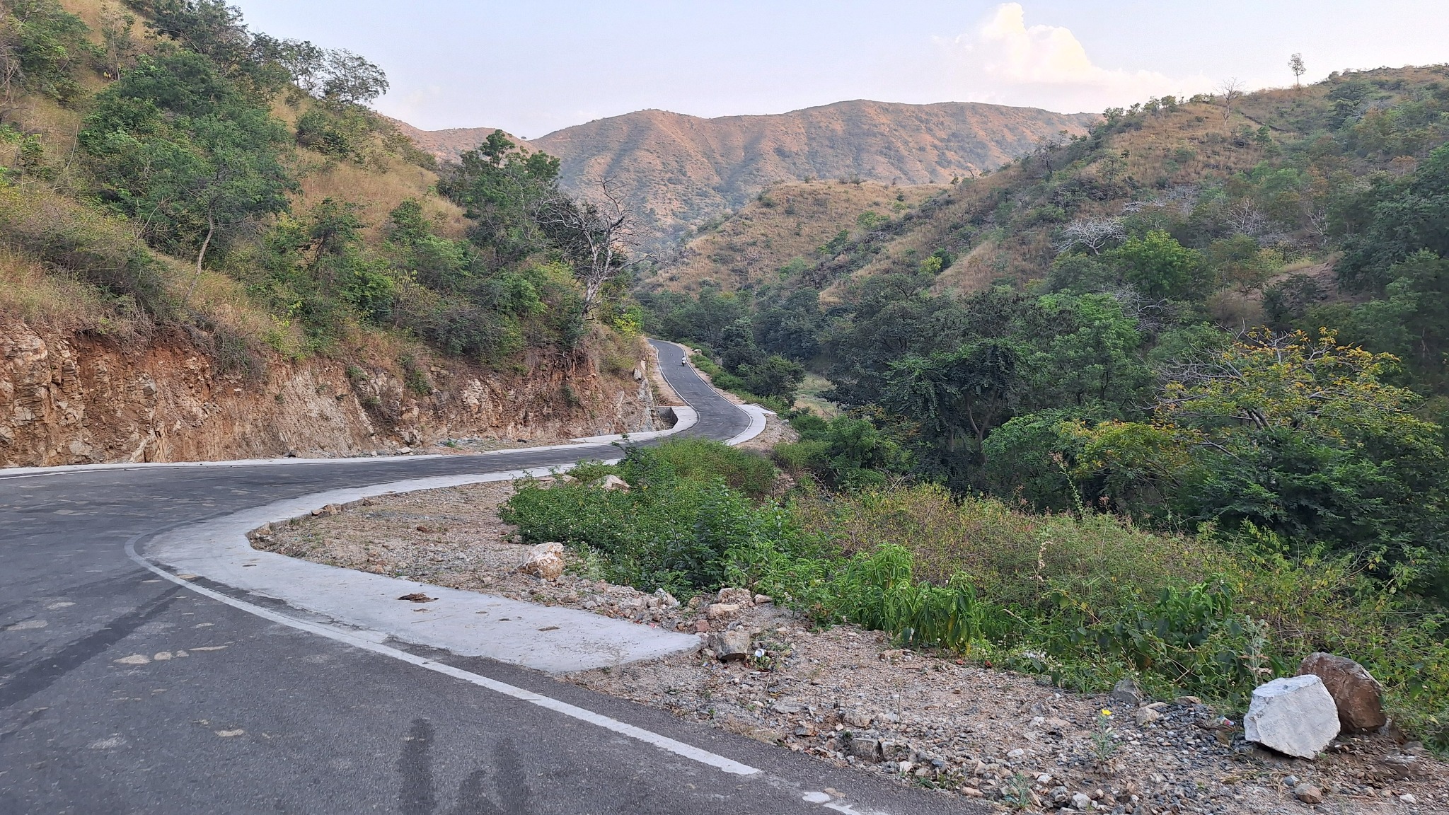A winding paved road through wooded hills
